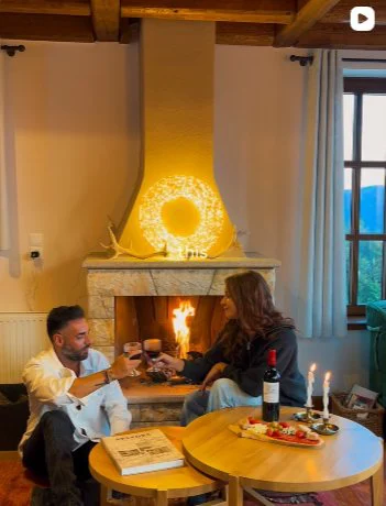 Ζευγάρι μπροστά στο τζάκι με κρασί