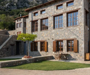 Πέτρινη πρόσοψη βίλας με ξύλινα παράθυρα